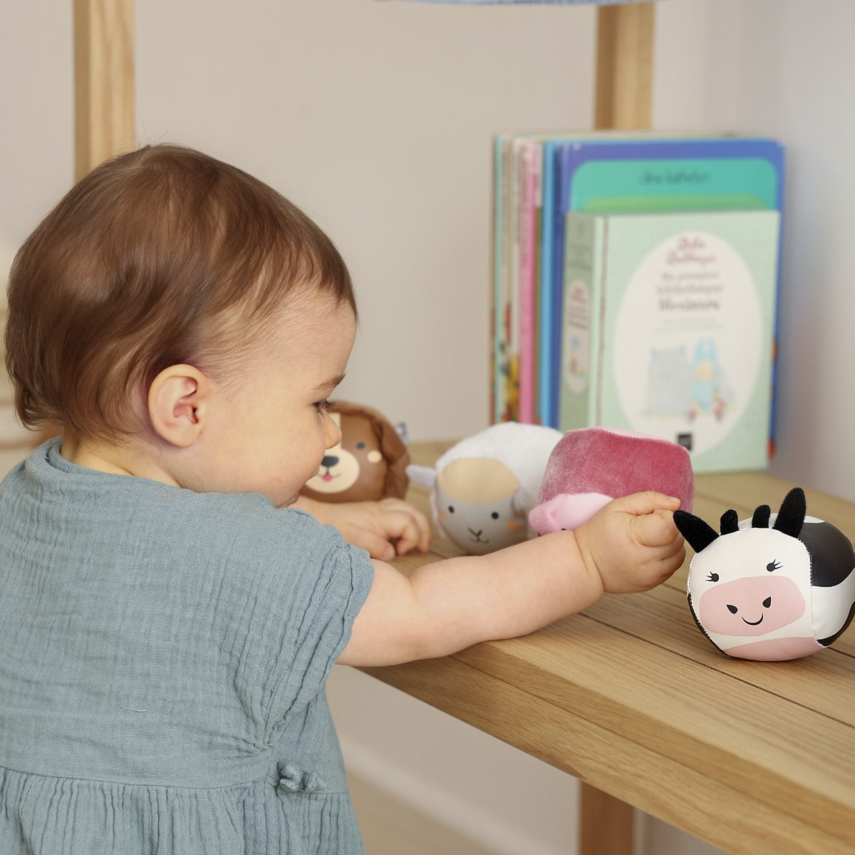 Little girl playing with Roly Poly farm animals soft balls