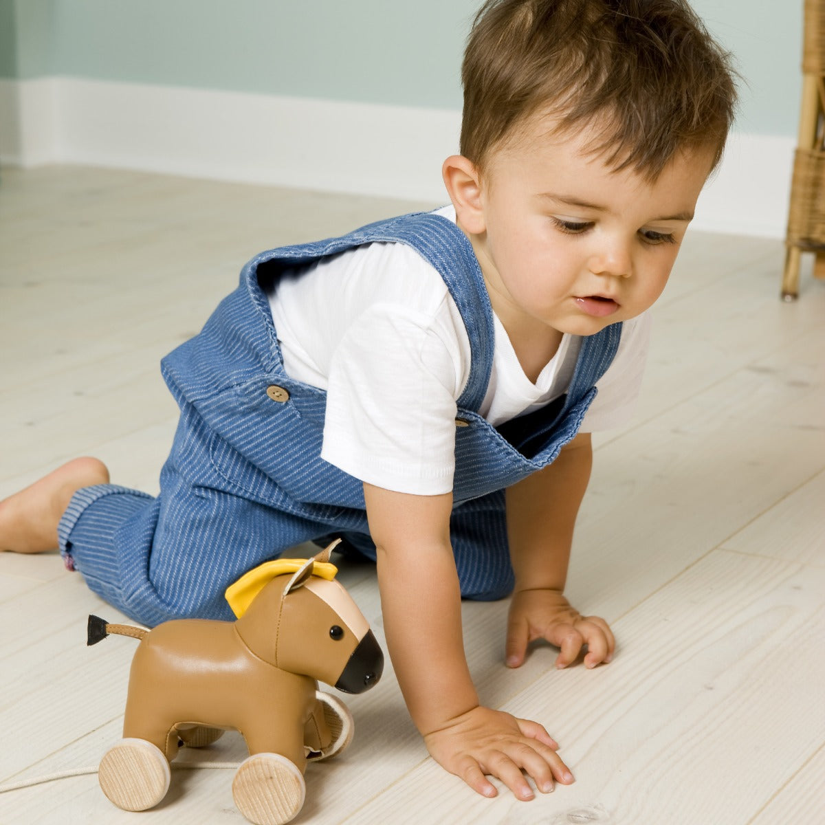Toddler boy playing with Pull Along horse from Little big Friends