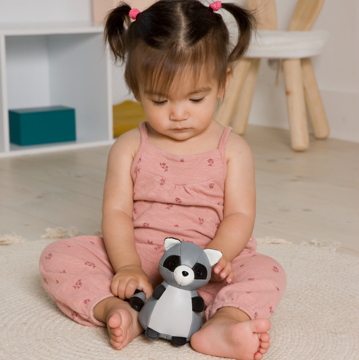 Baby girl playing with Tiny raccoon toy from little big friends