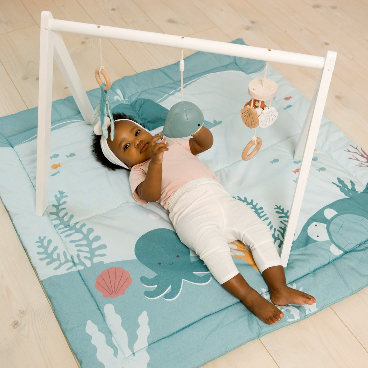 baby playing with Little big friends activity arch ocean while on ocean play mat