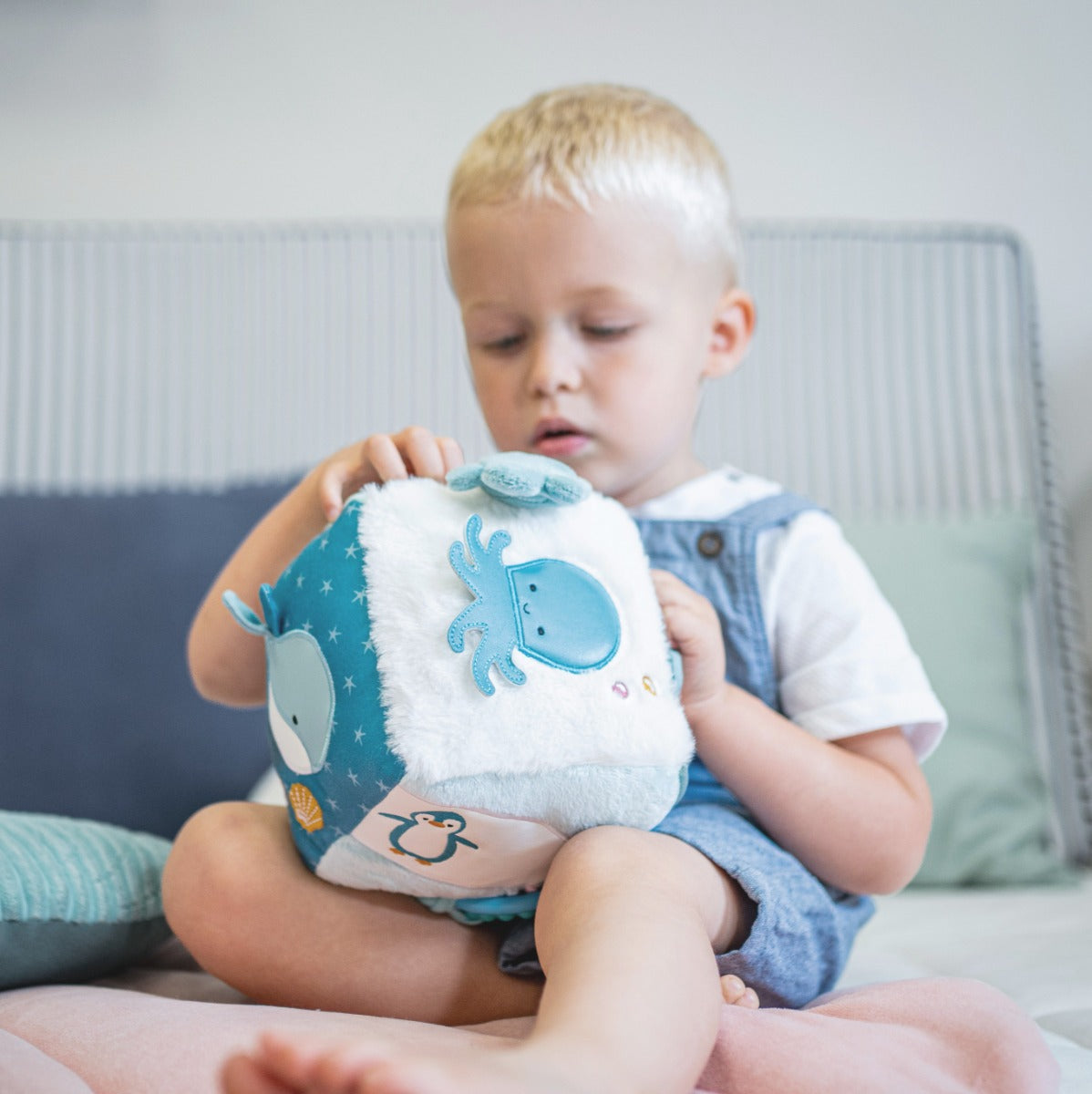 Tossler boy playing with Little Big Friends Soft Activity Cube Ocean  in bed