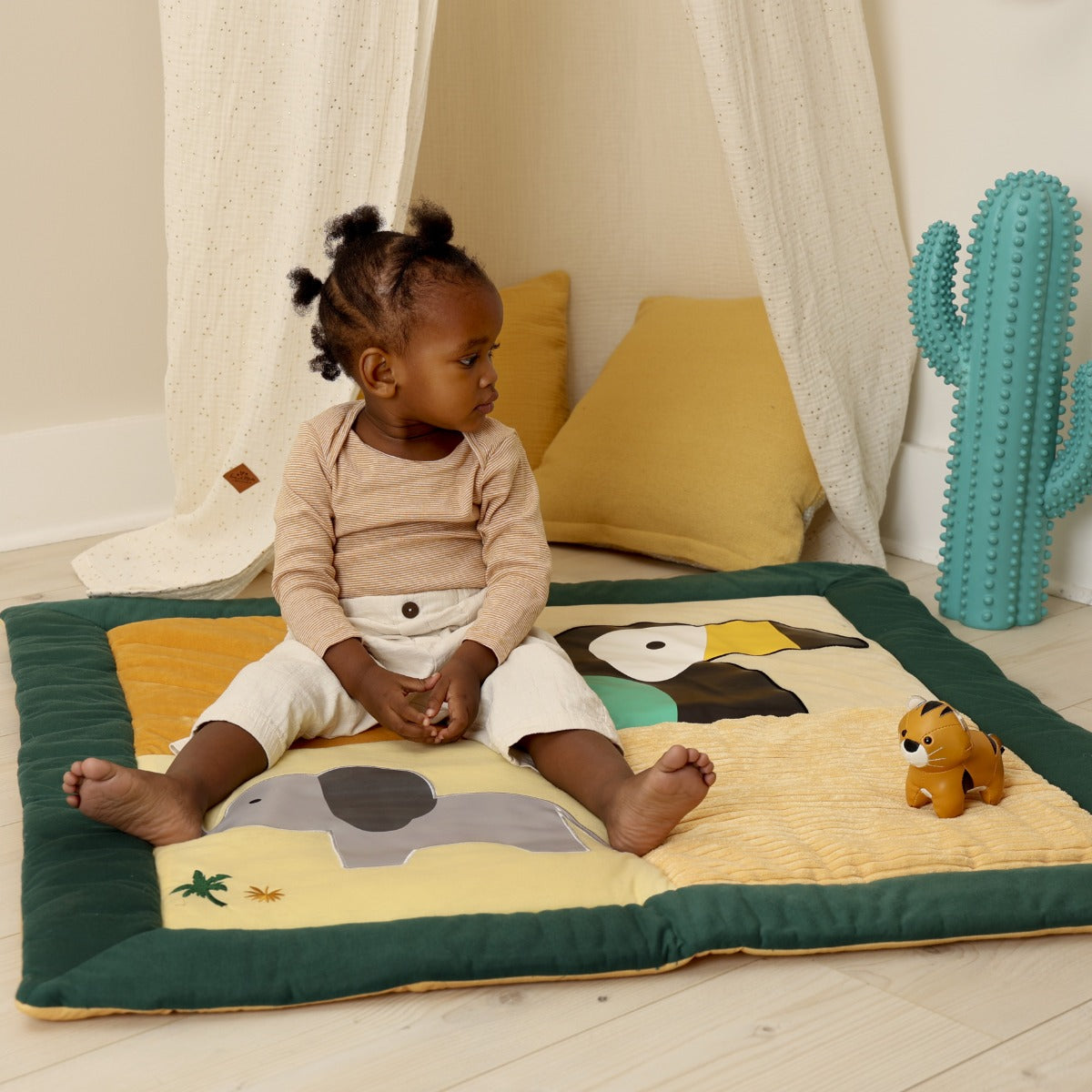 Baby playing with Little Big Friends Tiny Friends Tim the Tiger on a patchwork play mat