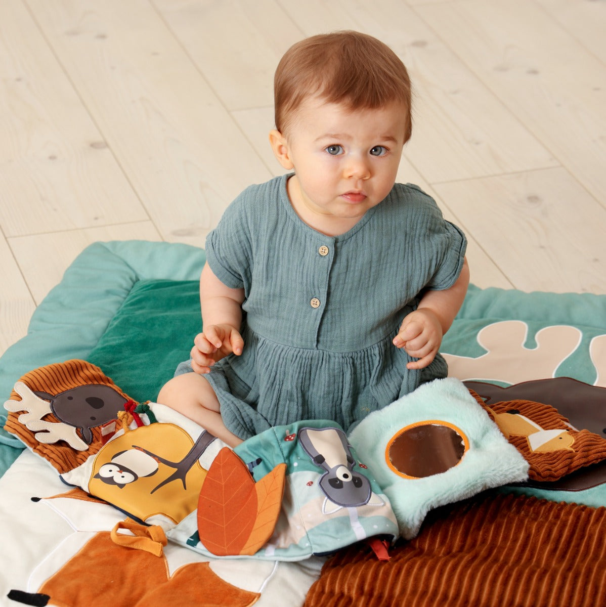 Baby playing with Little Big Friends Activity Book in forest theme