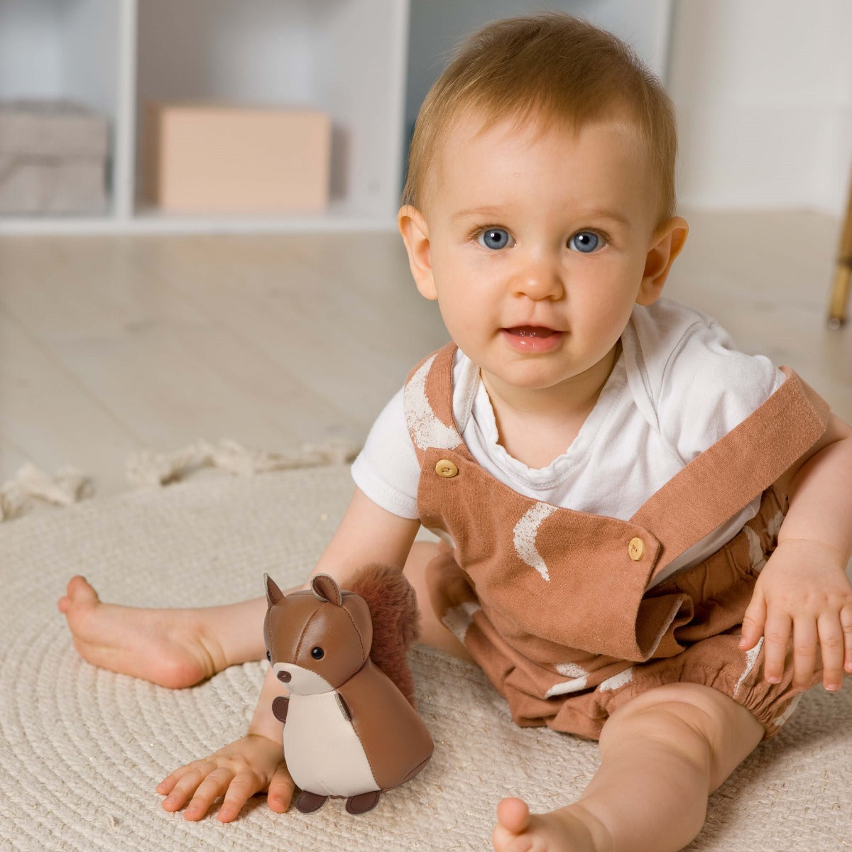 Baby boy playing with Tiny Squirrel Toy from Little Big Friends sitting on the floor