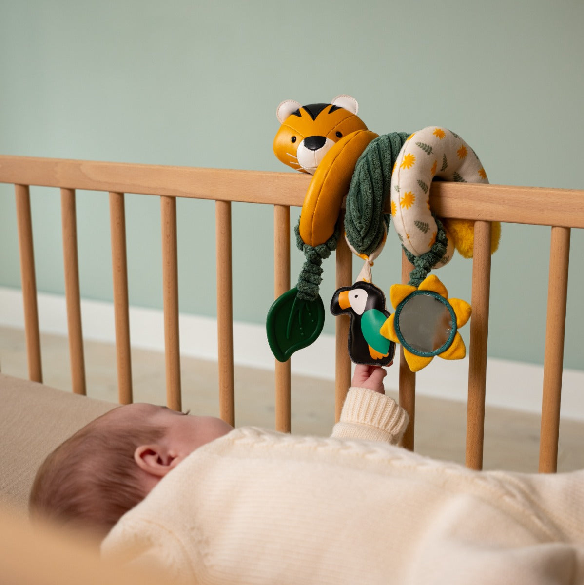 Baby playing in cot with Tiger head jungle theme activity spiral for kids from little big friends