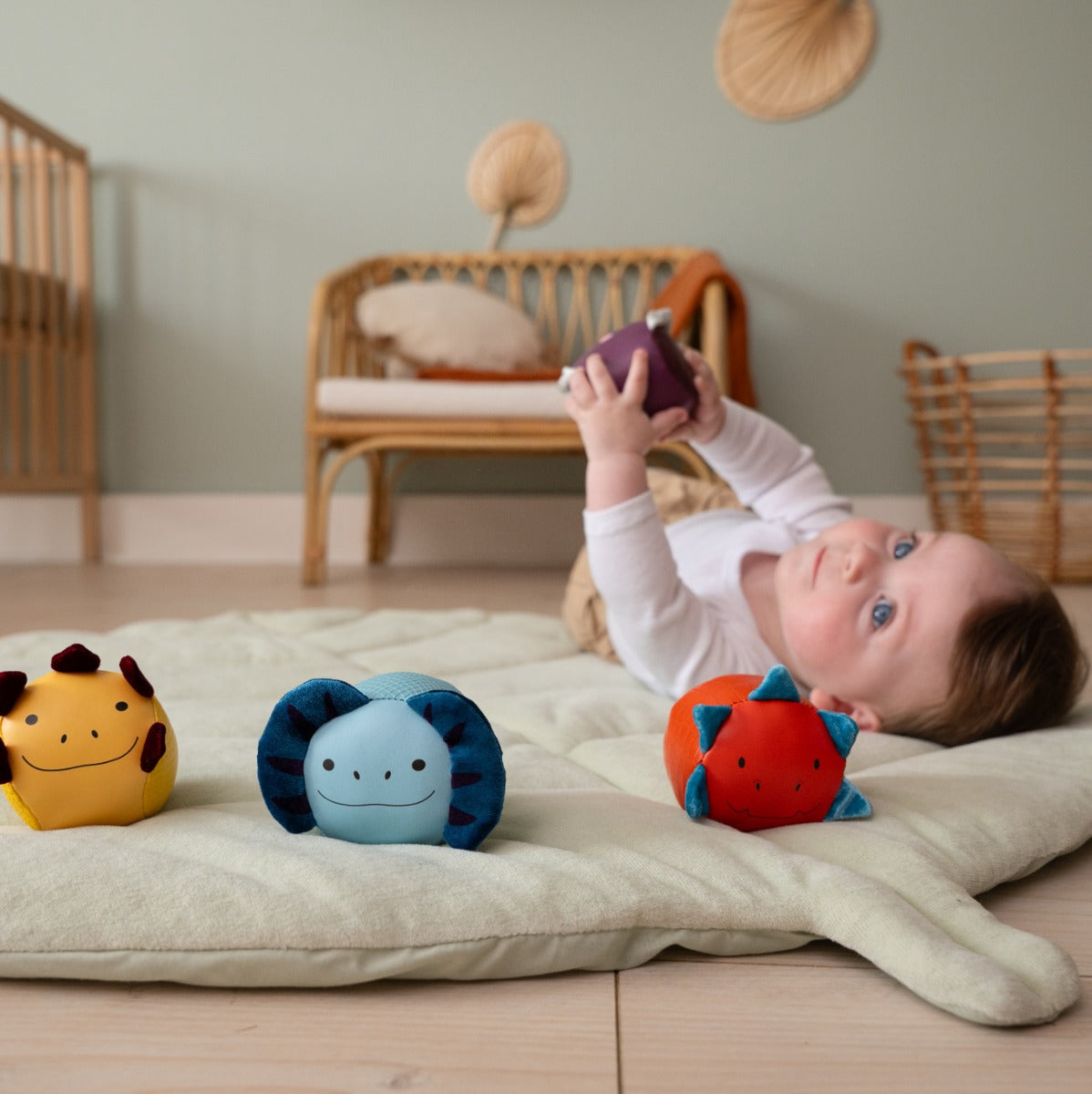 Baby boy playing with Roly Poly Soft dino animals balls from little big friends on playmat
