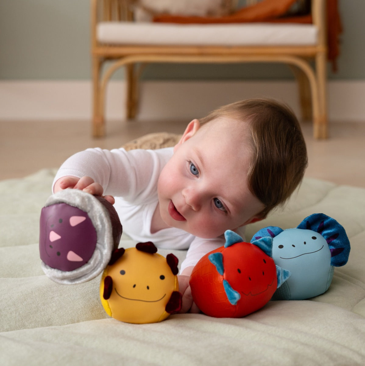 Baby boy playing with Roly Poly Soft dino animals balls from little big friends on playmat
