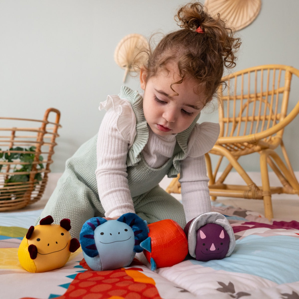 Girl playing with Roly Poly Soft dino animals balls from little big friends on playmat