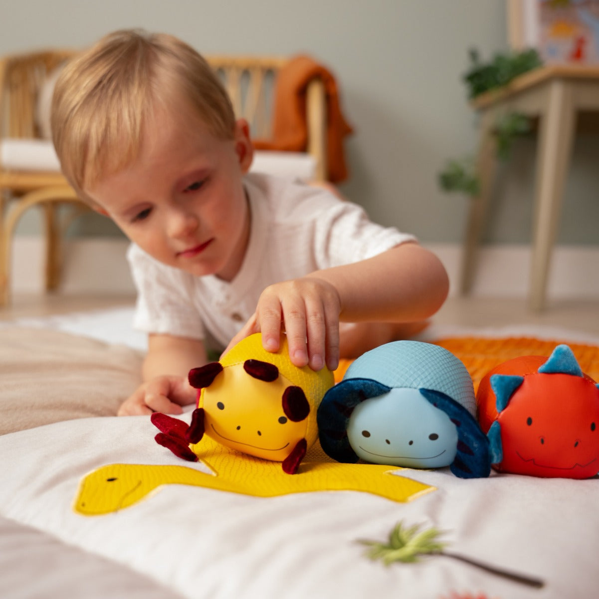 Baby boy playing with Roly Poly Soft dino animals balls from little big friends on playmat
