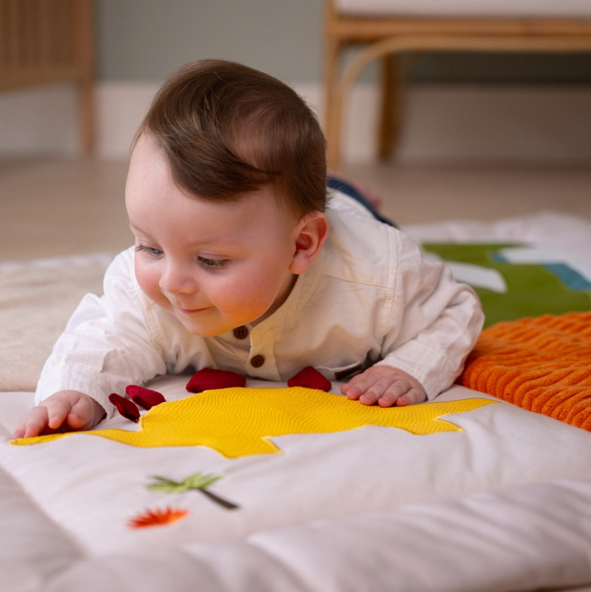 Baby crawling on a Patchwork kids reversible playmat in Dino theme in room