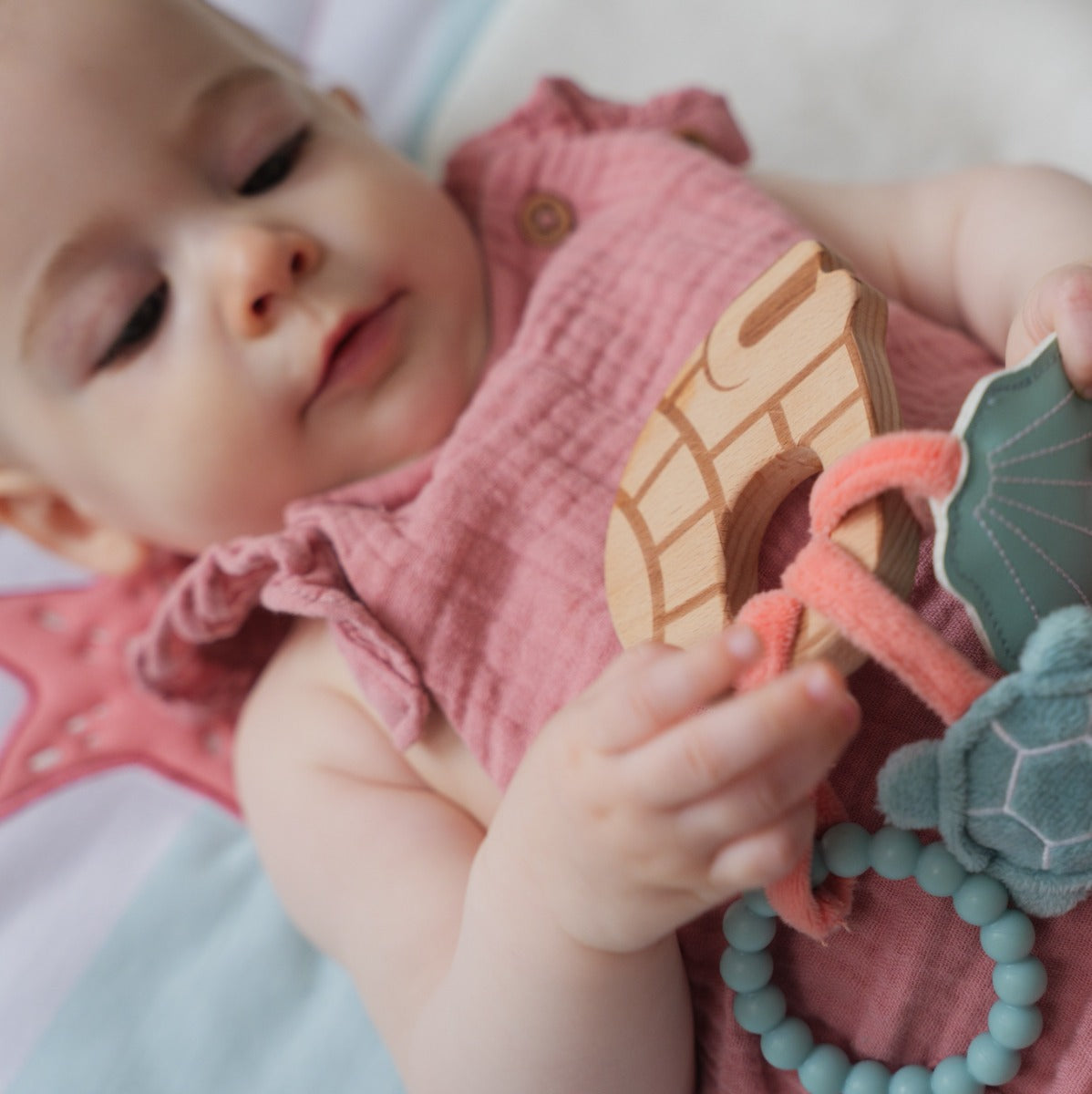 Baby playing with Little big friends wooden rattle with aquatic theme