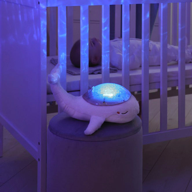 Baby sleeping in a cot with Tranquil nightlight