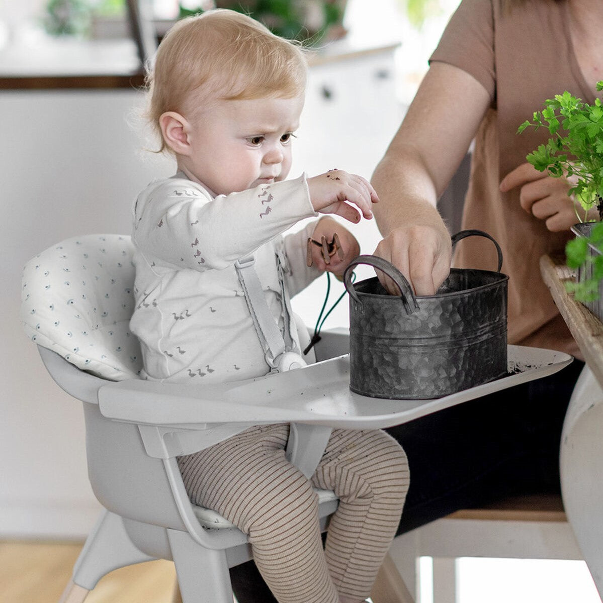 baby sitting in blueberry boat cushion for the stokke clikk highchair
