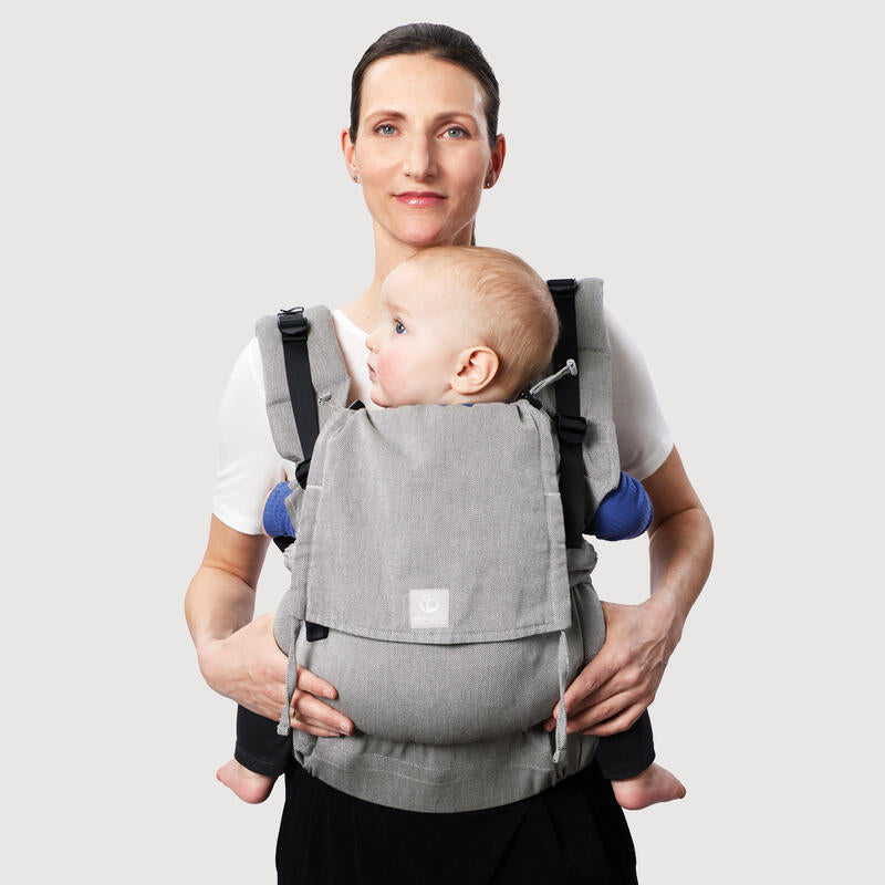 Mother carrying baby in Stokke Limas Carrier plus in Grey Melan facing front.
