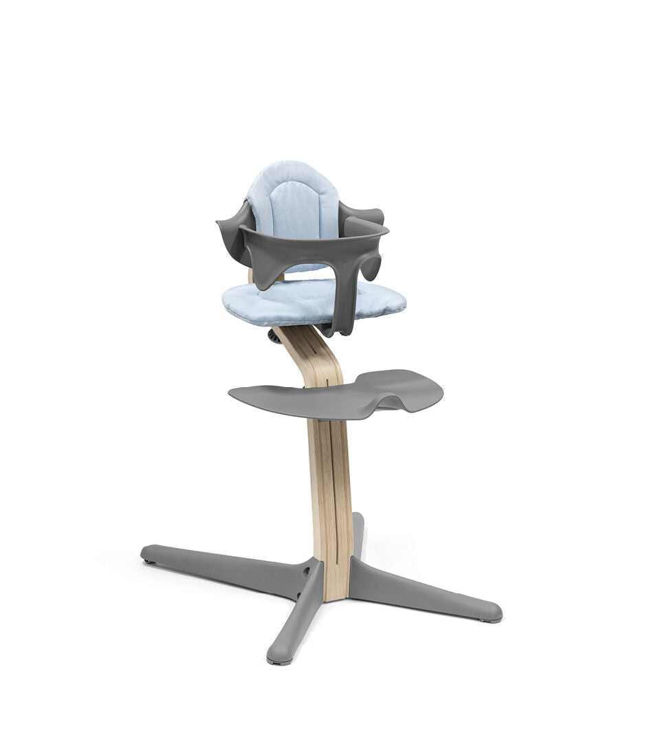 Nomi Blue cushion from Stokke attached in a chair with babyset