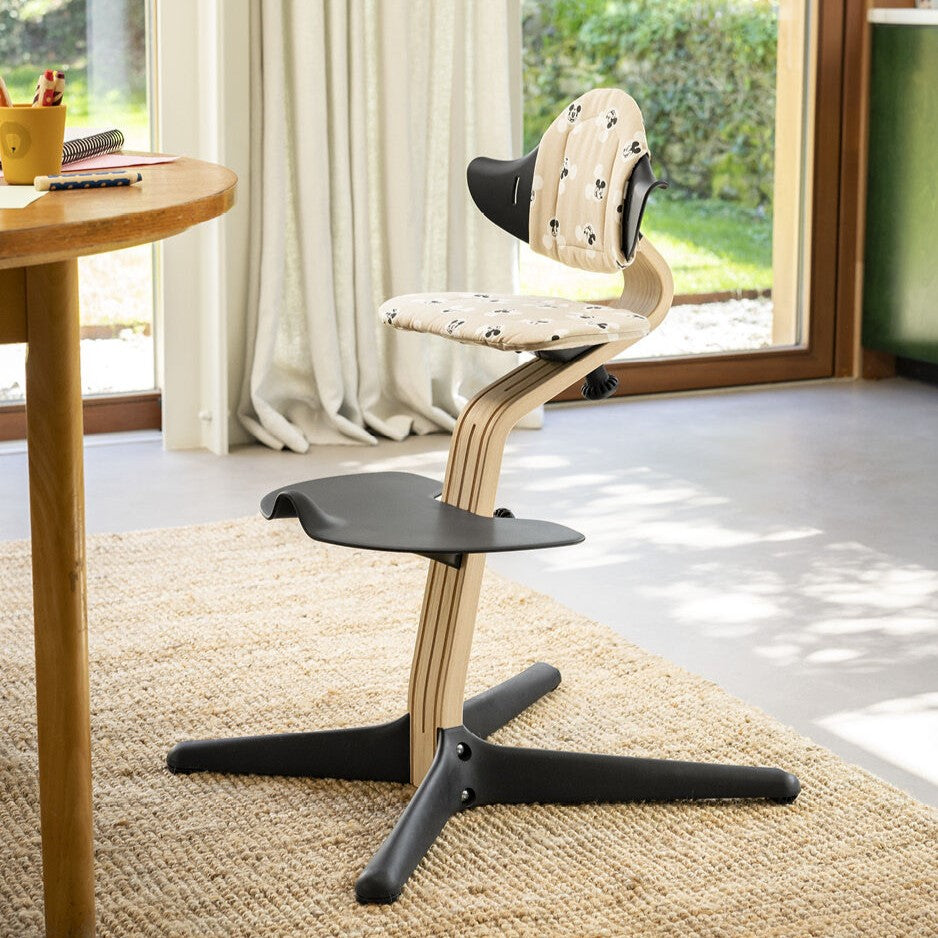 Nomi cushion with Mickey Mouse Print from Stokke attached with a chair in a room