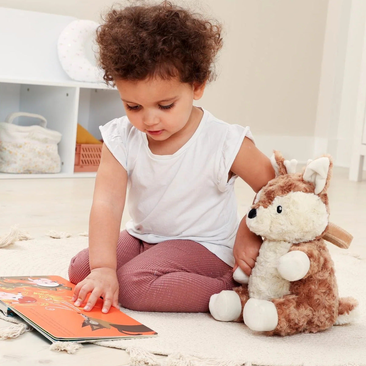 Baby holding Lovelight Buddies - Finley Fawn while reading 