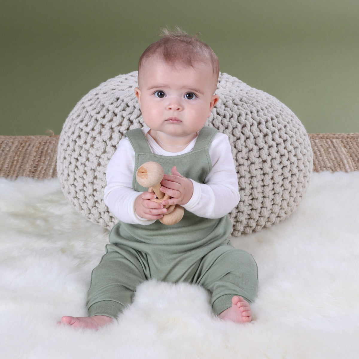 Baby wearing Arctic Adventure Merino Overall in Moss pairing it with natural essential sleeve top