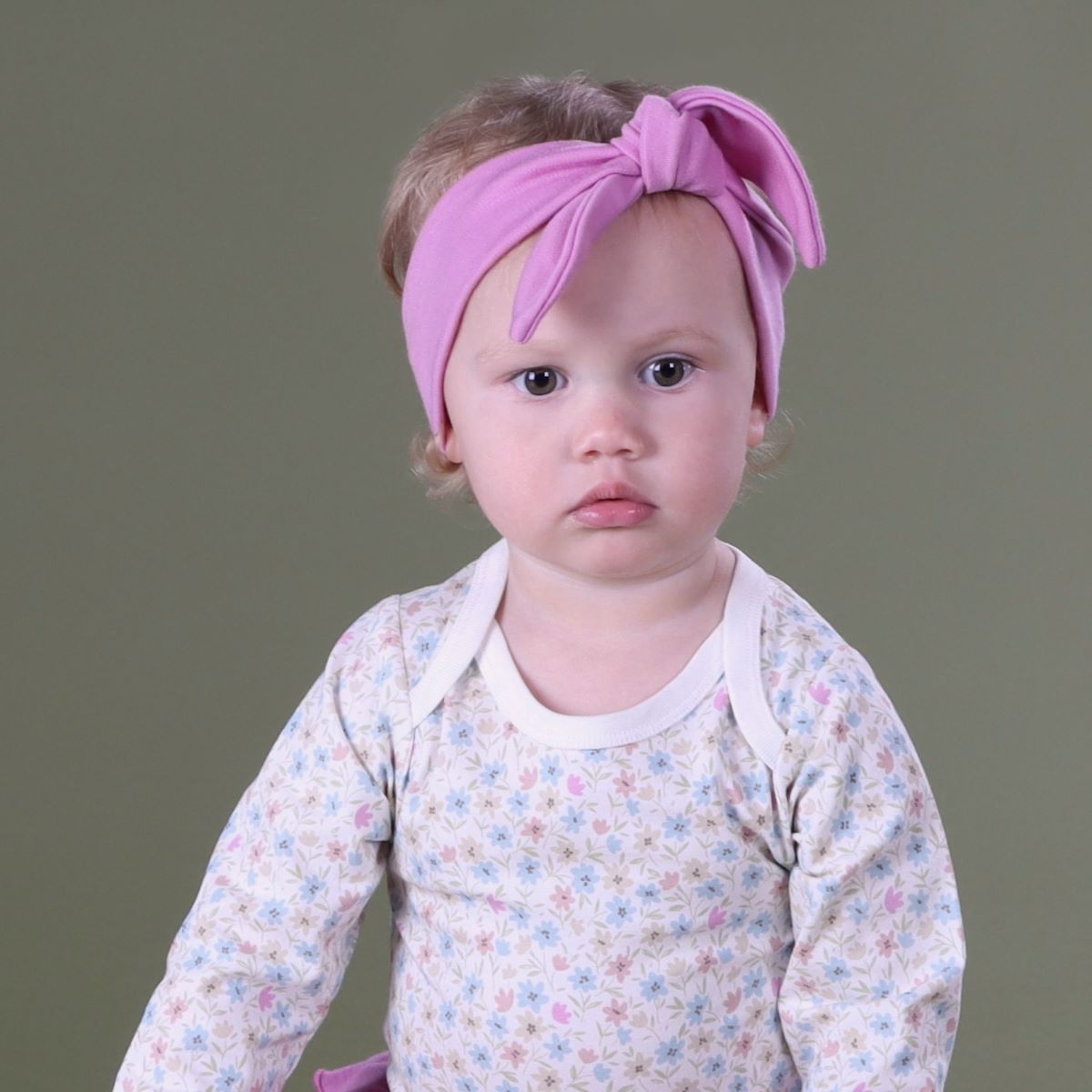 Baby girl wearing orchid Merino Head band pairing it with wildflower bodysuit