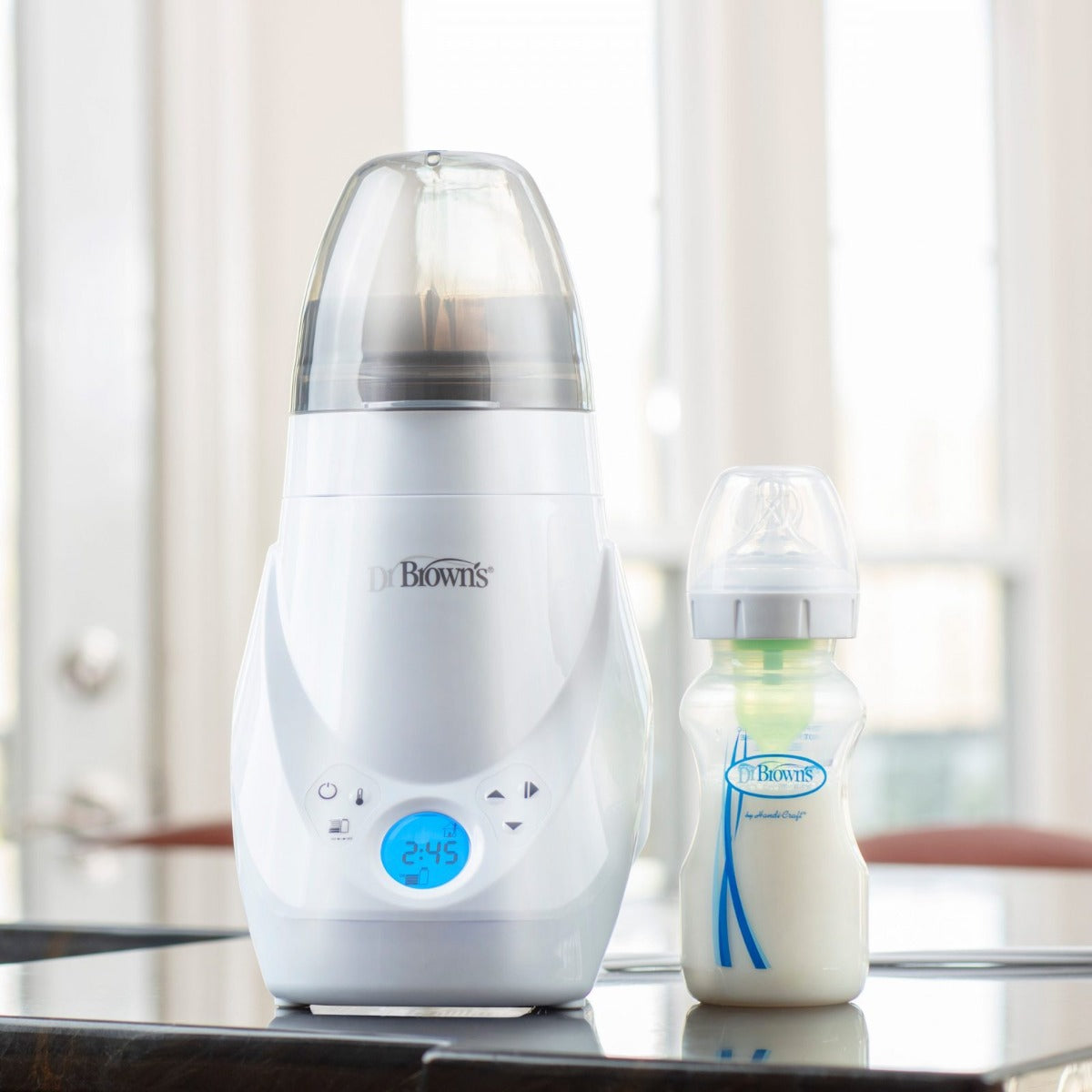 Dr Brown's Deluxe Bottle Warmer and Steriliser sitting on a counter top with a bottle 