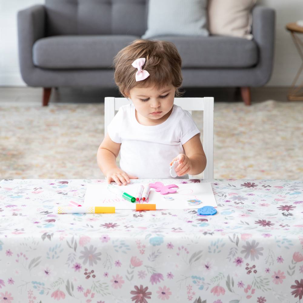 Girl playing with playdough on Floral summer vibes waterproof splat mat from Bumkins.