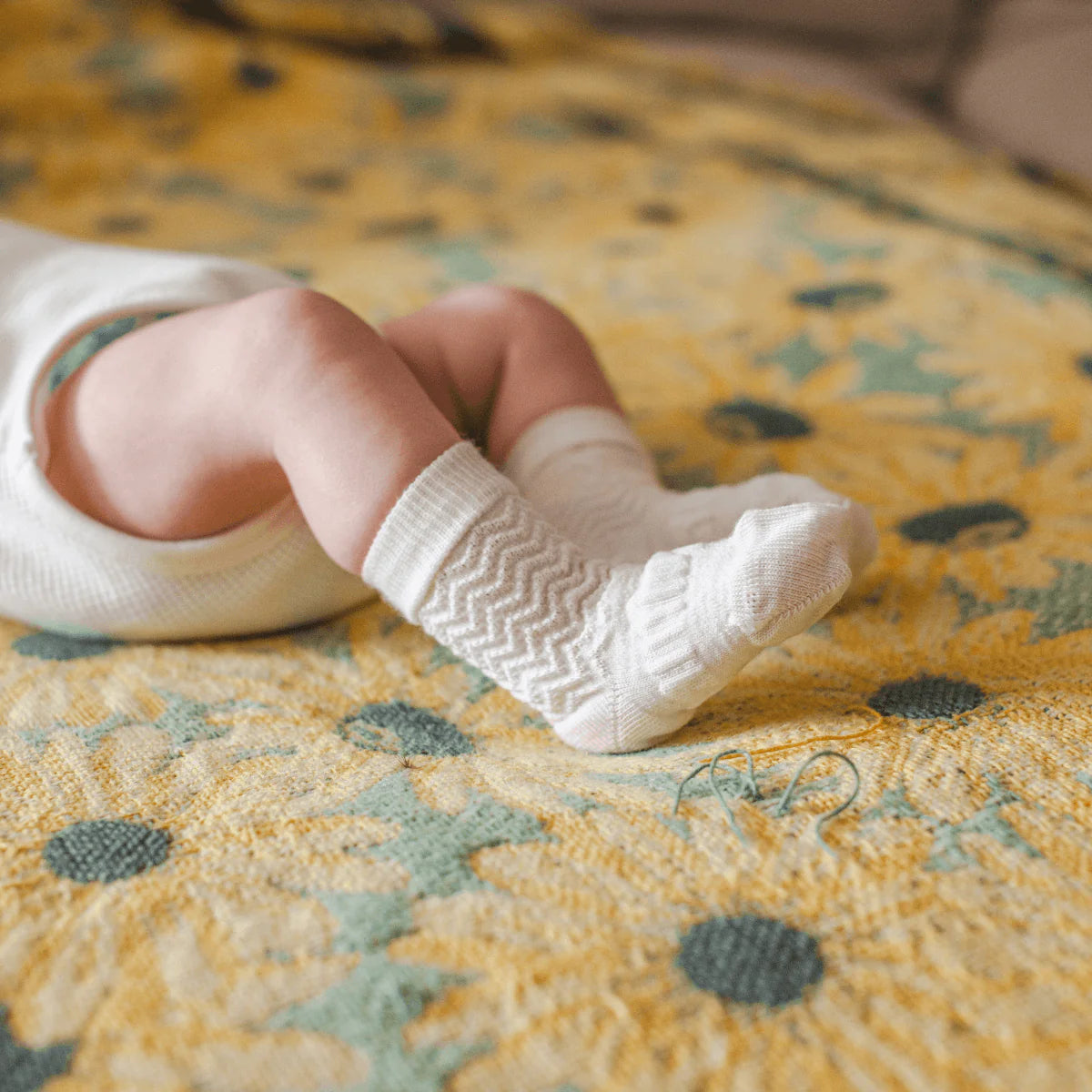 Baby wearing Baby Merino Wool Crew Socks in pearl white with zig zag pattern