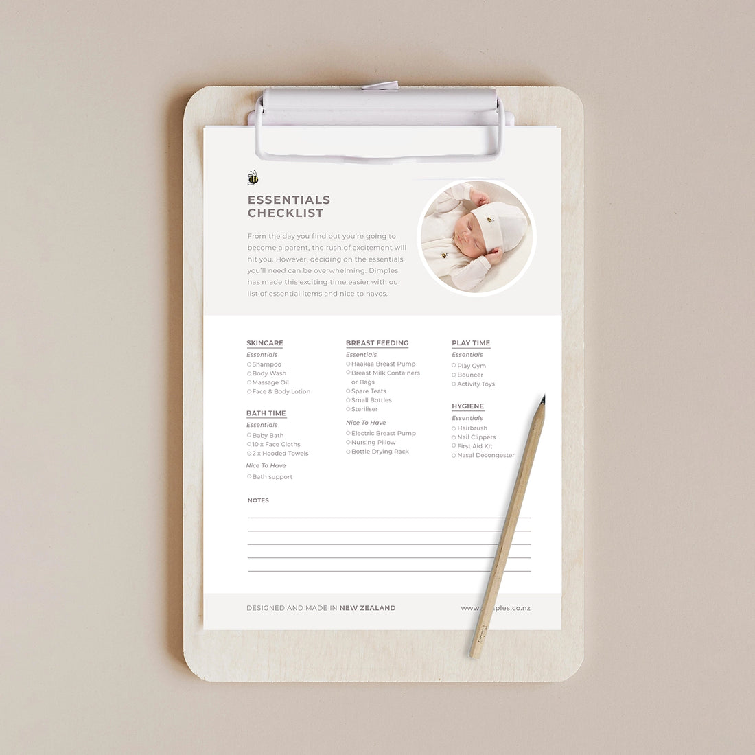 Checklist for new parents on a clipboard with a pencil on a beige background