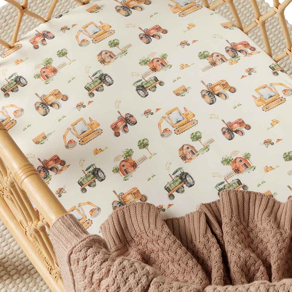 Snuggle Hunny Bassinet Sheet with Diggers and Tractors print in a bassinet with blanket