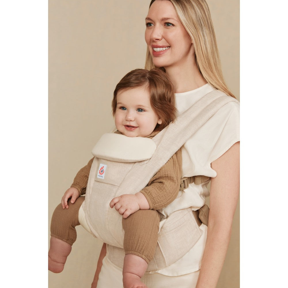 Mother carrying baby in linen baby carrier