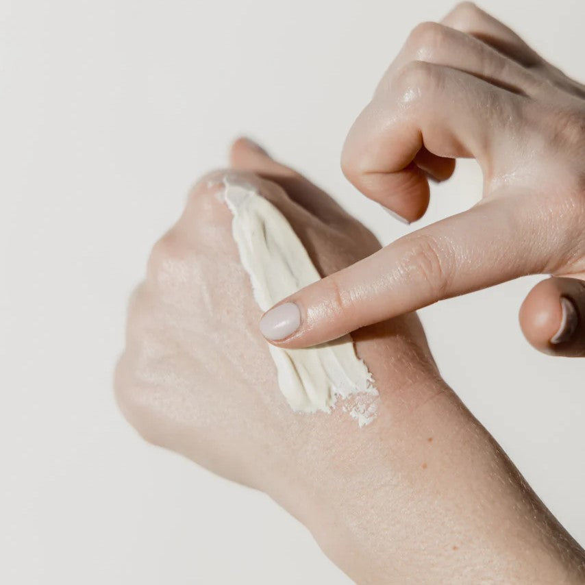 Mother applying Beetl baby balm tube on hand