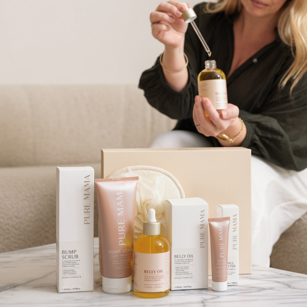 pregnant women holding a bottle of pure mama belly oil