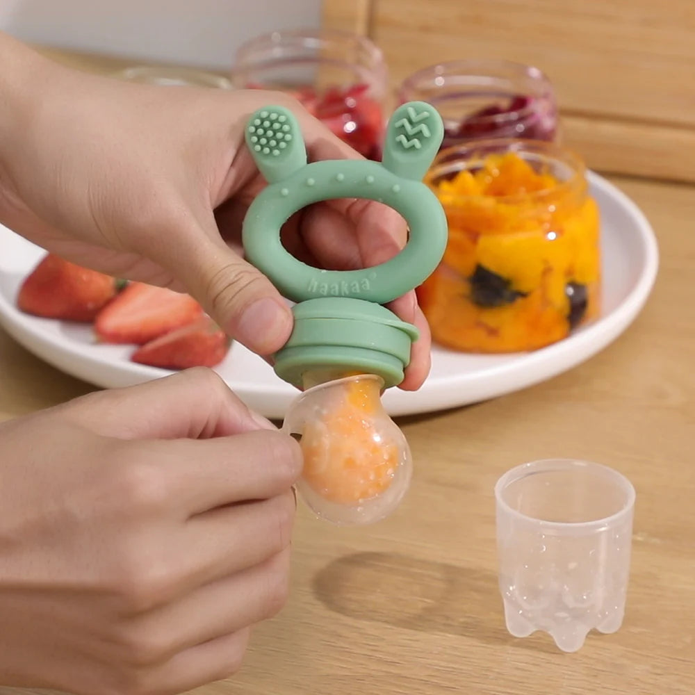 Inserting food into feeder teether from Haaka