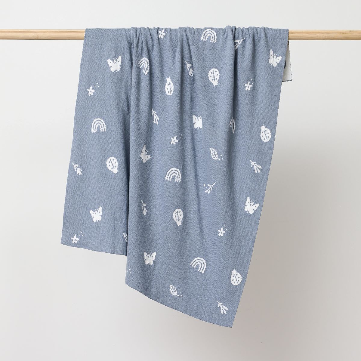 Sky Blue coloured blanket with butterflies, betelnuts, flowers and leavers printed in white hanging on the wooden rod to display.:image,small_image,thumbnail,swatch_image