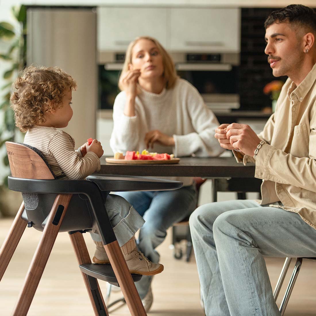 Baby sitting in Bryn Highchair with parents around dining table