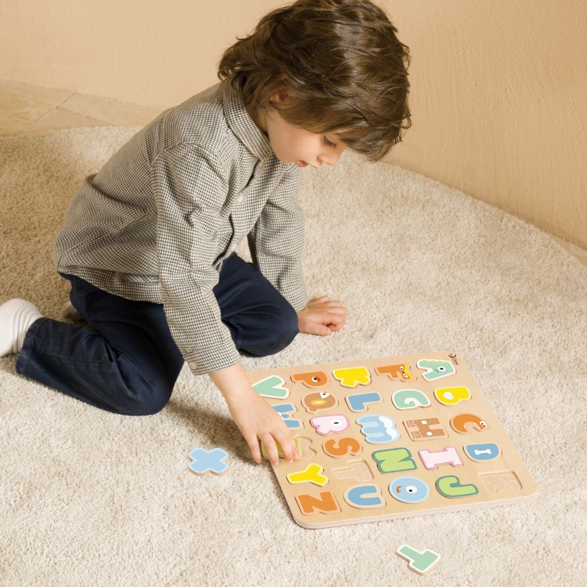 Boy playing wooden alphabet puzzle