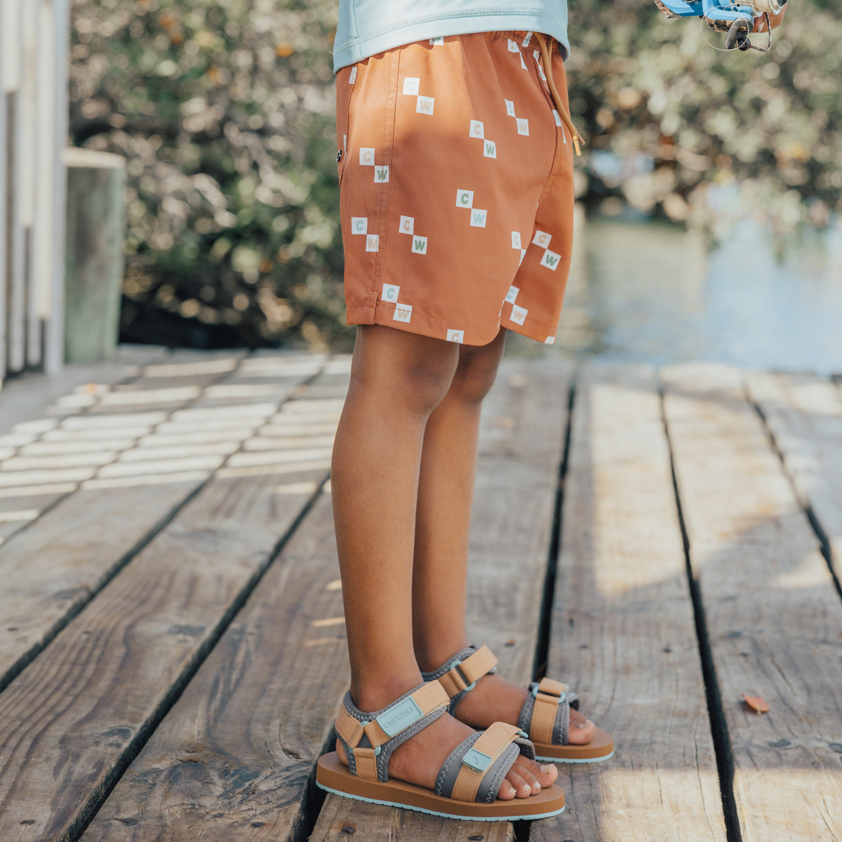 Boy wearing Crywolf Board Shorts with Vacation print and sandels