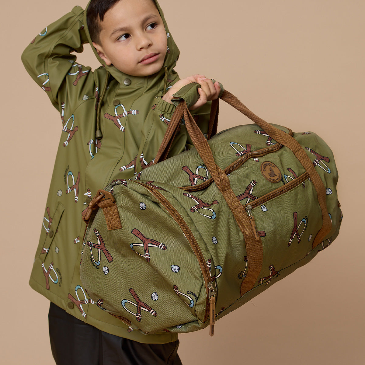 Toddler boy holding Catapult print recycled duffel bag