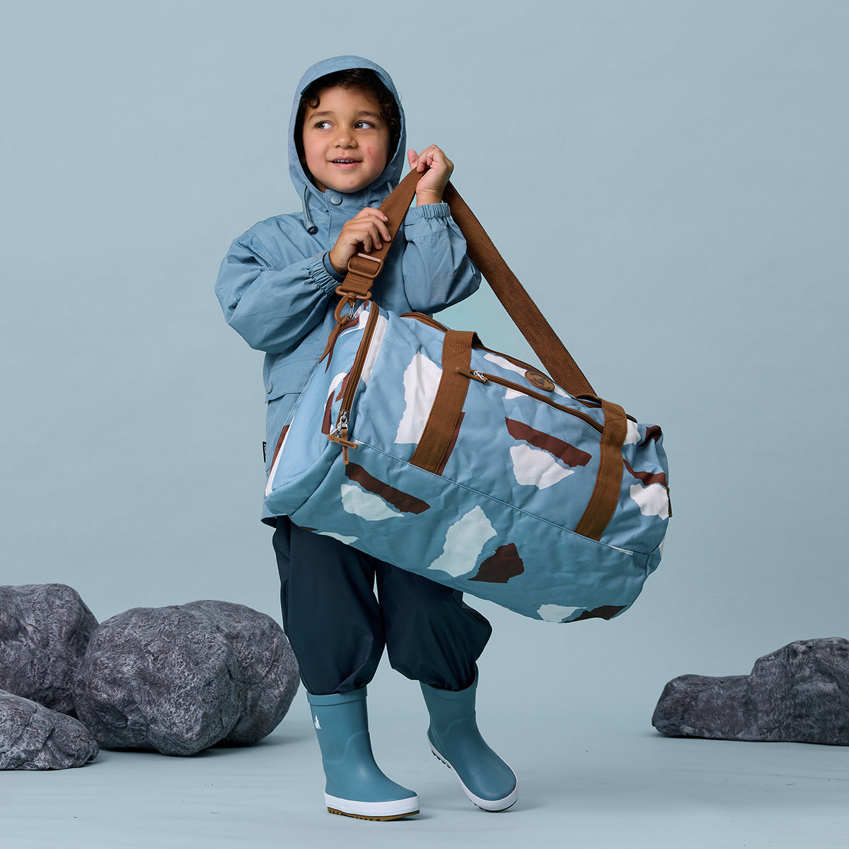 Toddler boy holding Mountain print recycled duffel bag