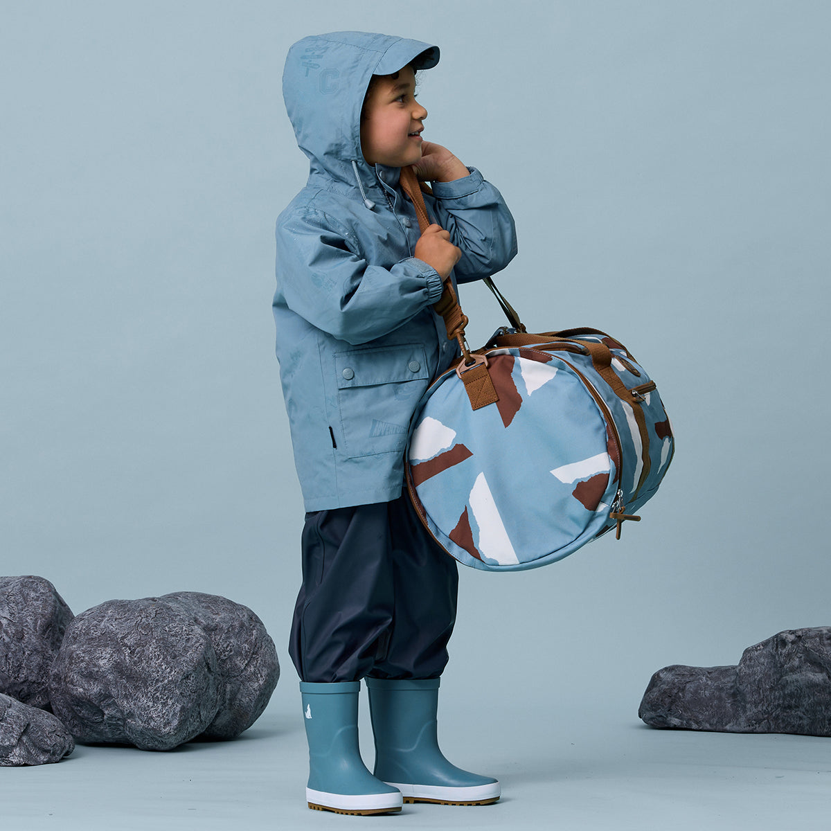 Toddler boy holding Mountain print recycled duffel bag