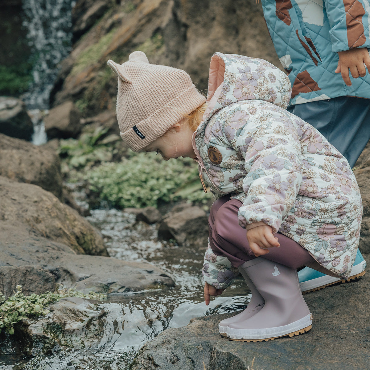 Girl near waterfall wearing Crywolf Wolf ears beanie in dusty 