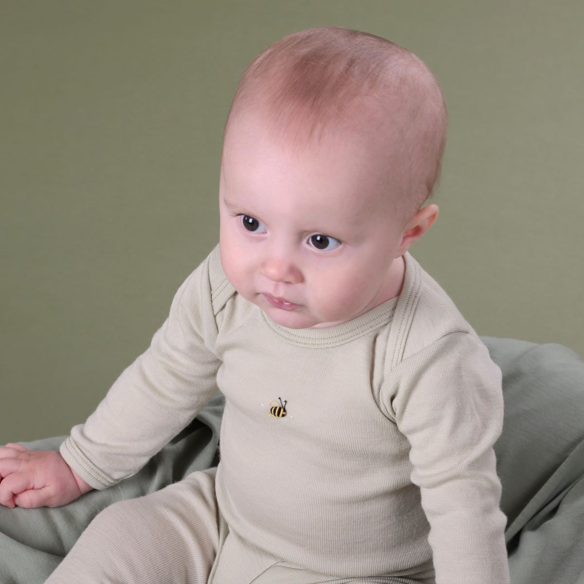 Baby wearing long sleeve onesie front view with bee embroidery pairing it with merino leggings