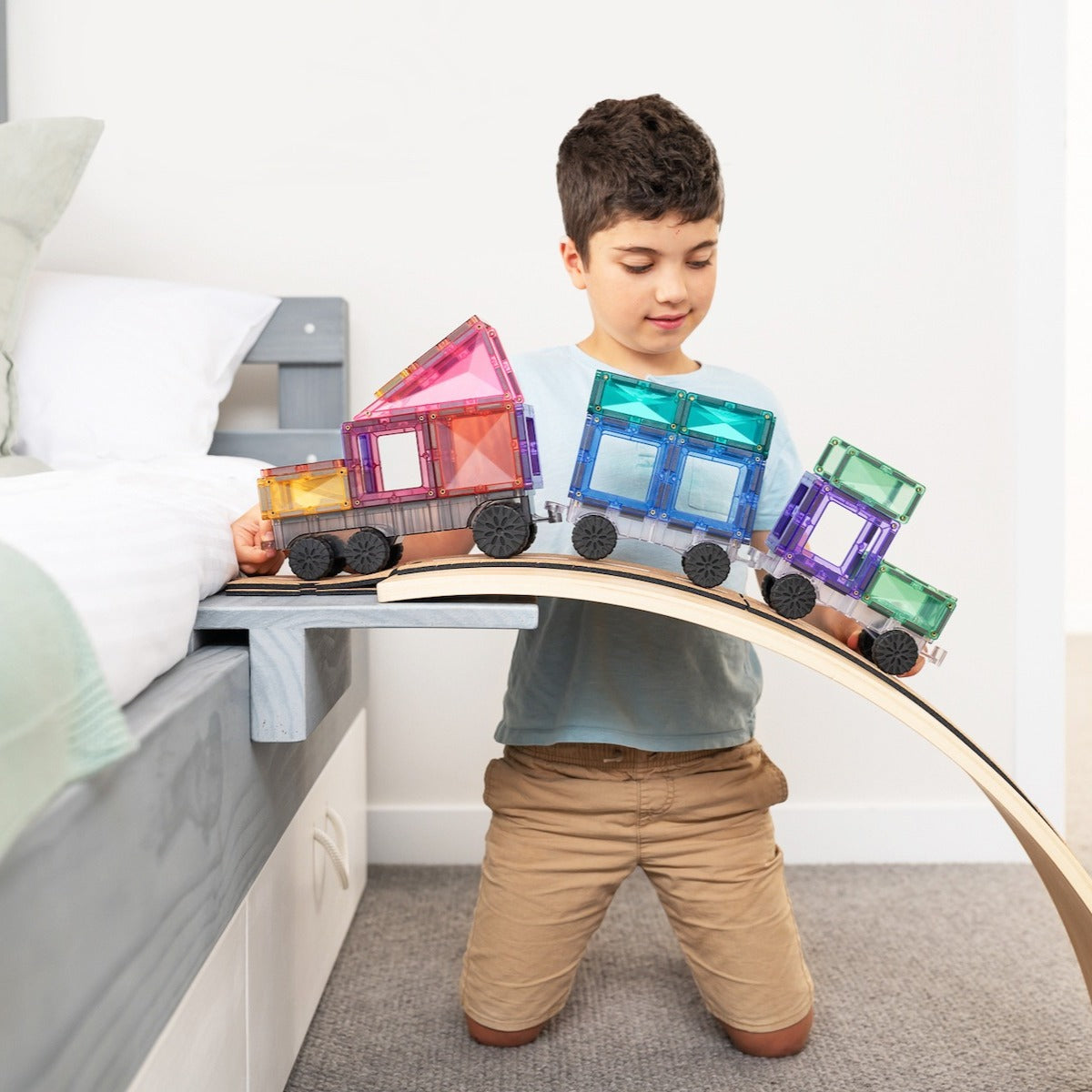 boy playing with 50pcs Pastel Transport Tiles Pack box on tracks 