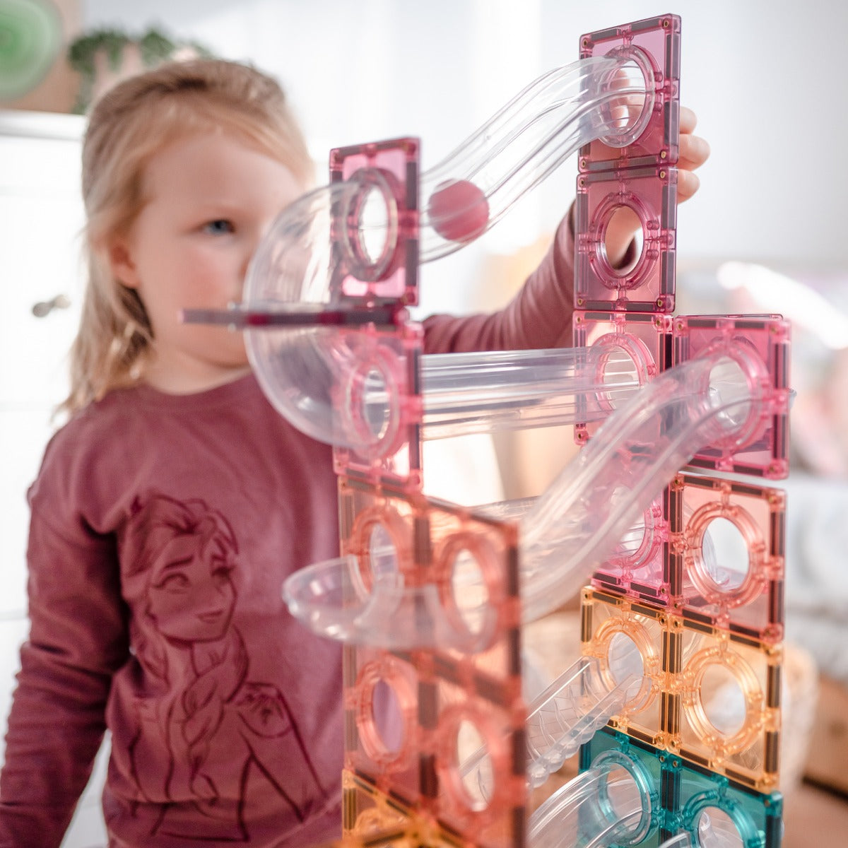 Little girl playing with 106pcs Patel Ball Run Tiles Pack
