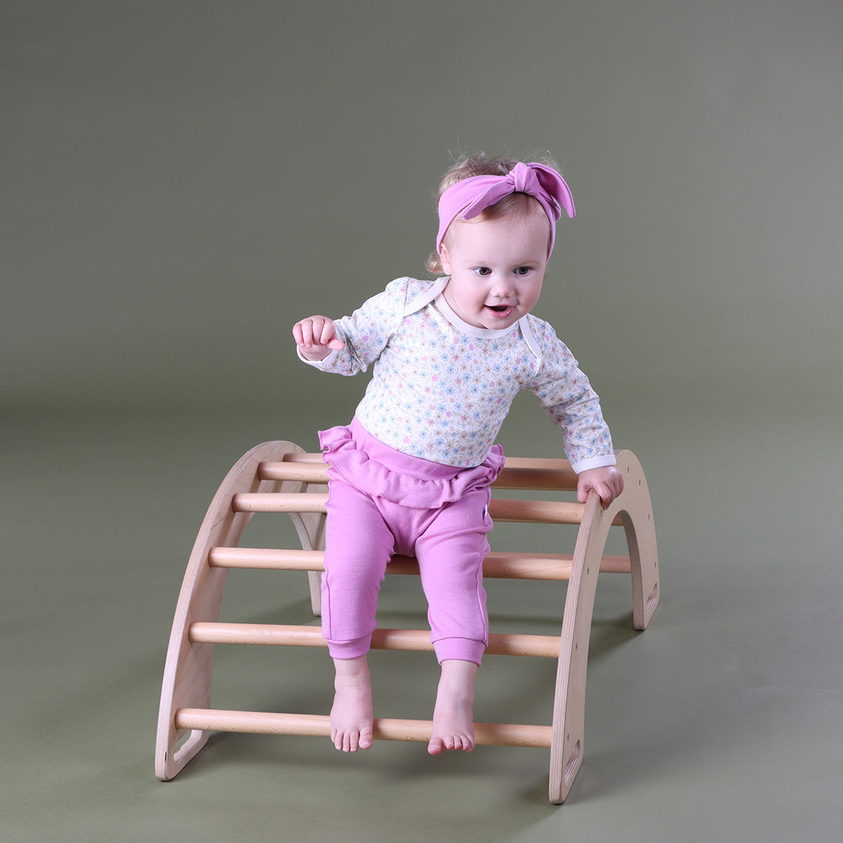 Girl child standing on climbing and rocking arch from Kinderfeets