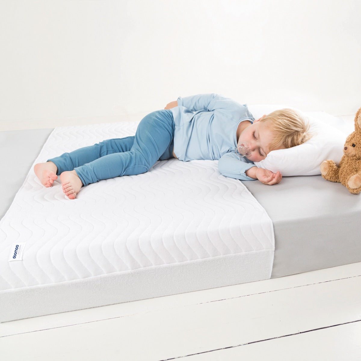 Baby boy sleeping on a Absoplus mattress protector :image,small_image,thumbnail,swatch_image