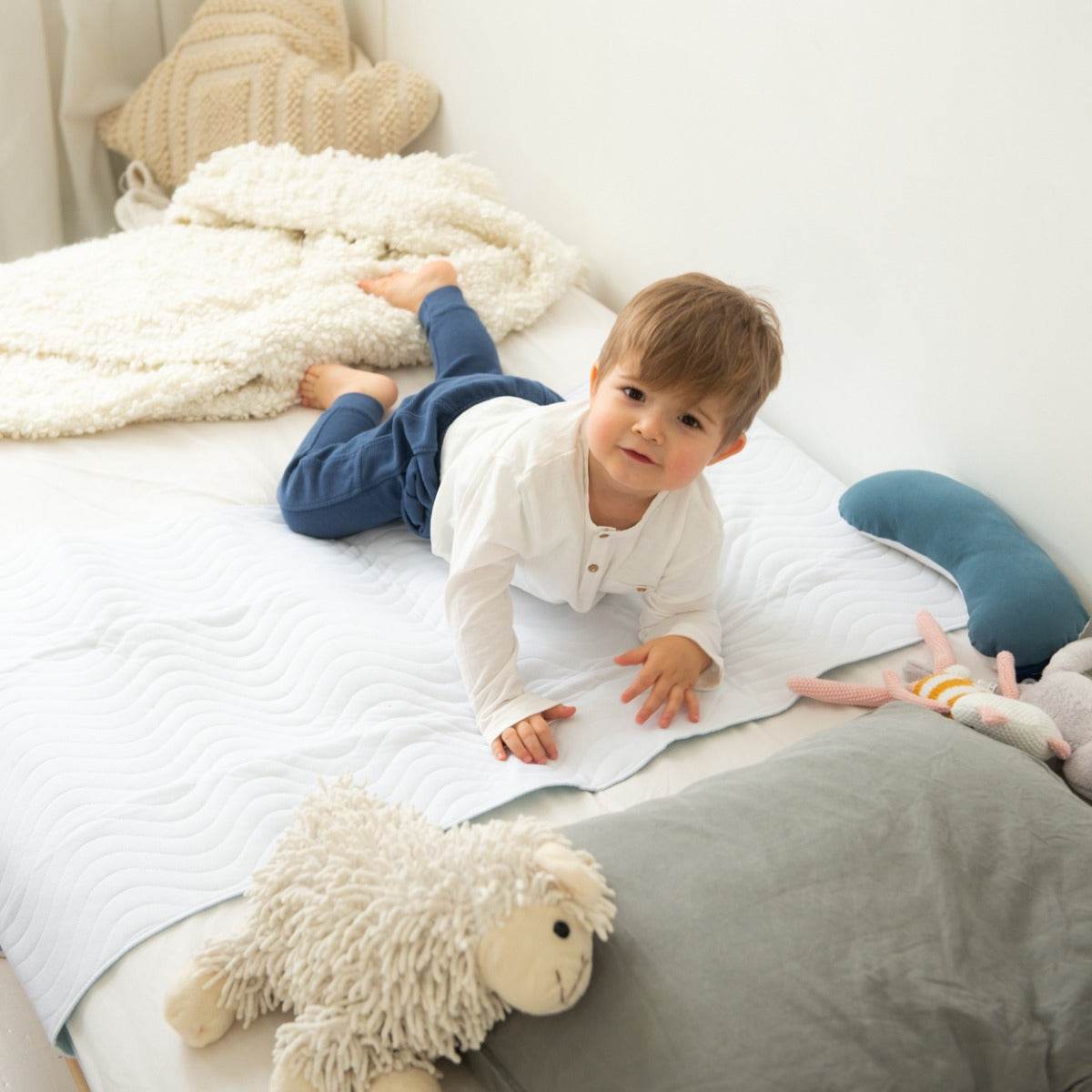 Baby boy sleeping on a Absoplus mattress protector 