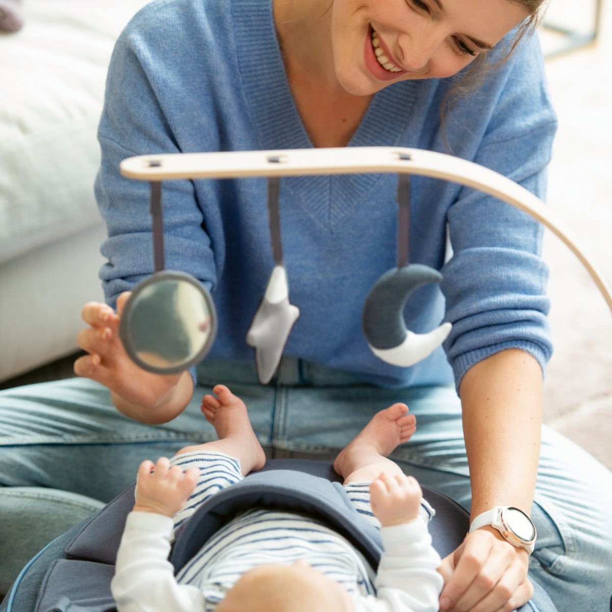 Baby sleeping on Seat'N Swing and staring at Arch with star, sun and moon