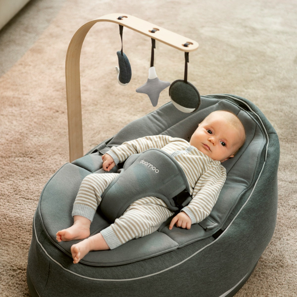 Baby sleeping on Seat'N Swing an staring at Arch with star, sun and moon