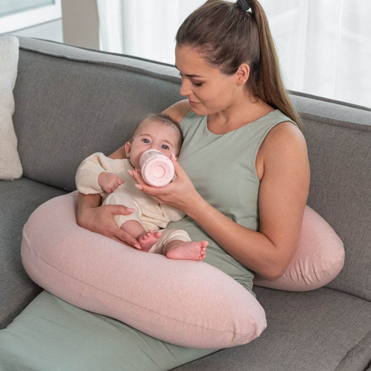 Women bottle feeding baby with Doo Moo Chine Pink Pregnancy Pillow