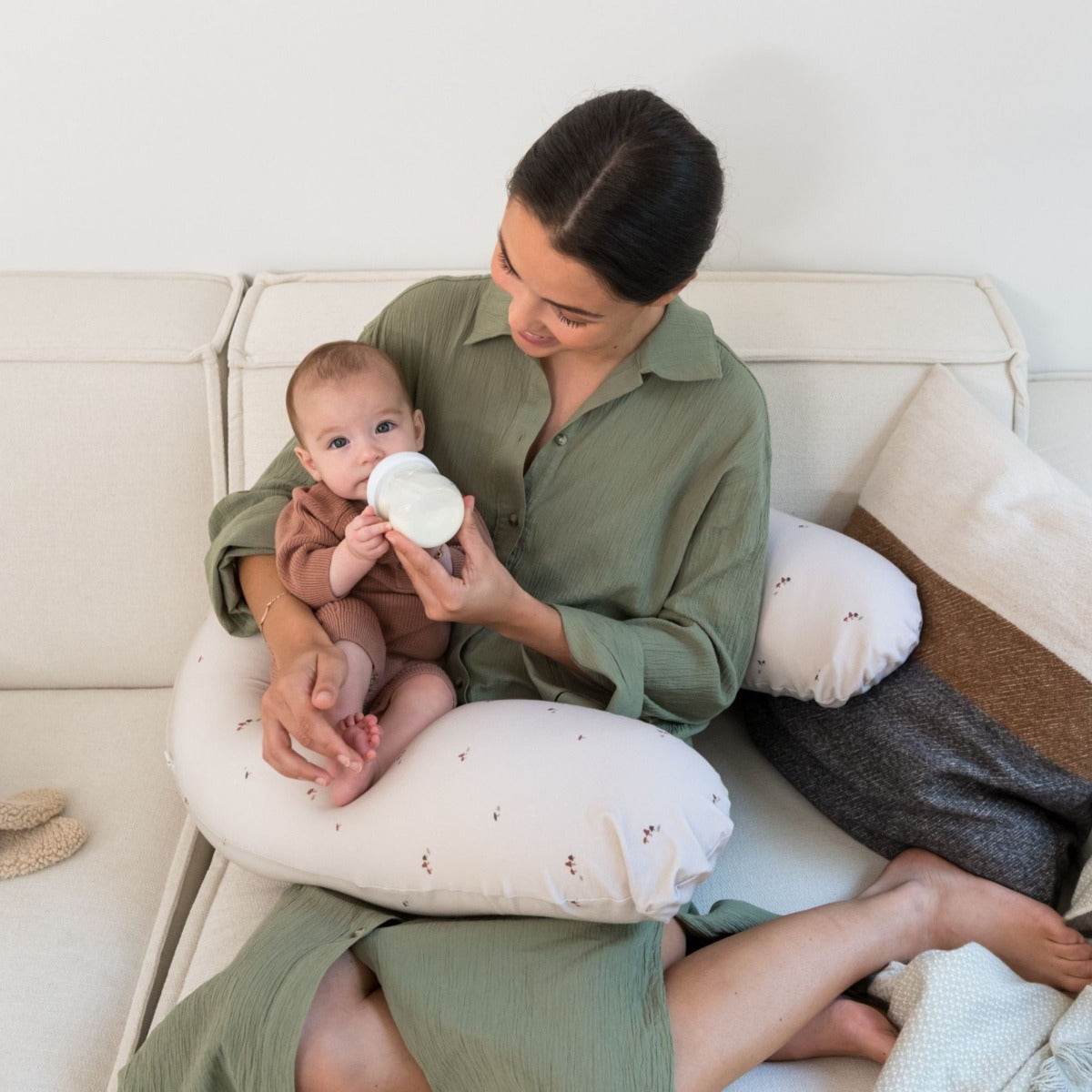 Women bottle feeding baby with Doo Moo Mushrooms Pregnancy Pillow